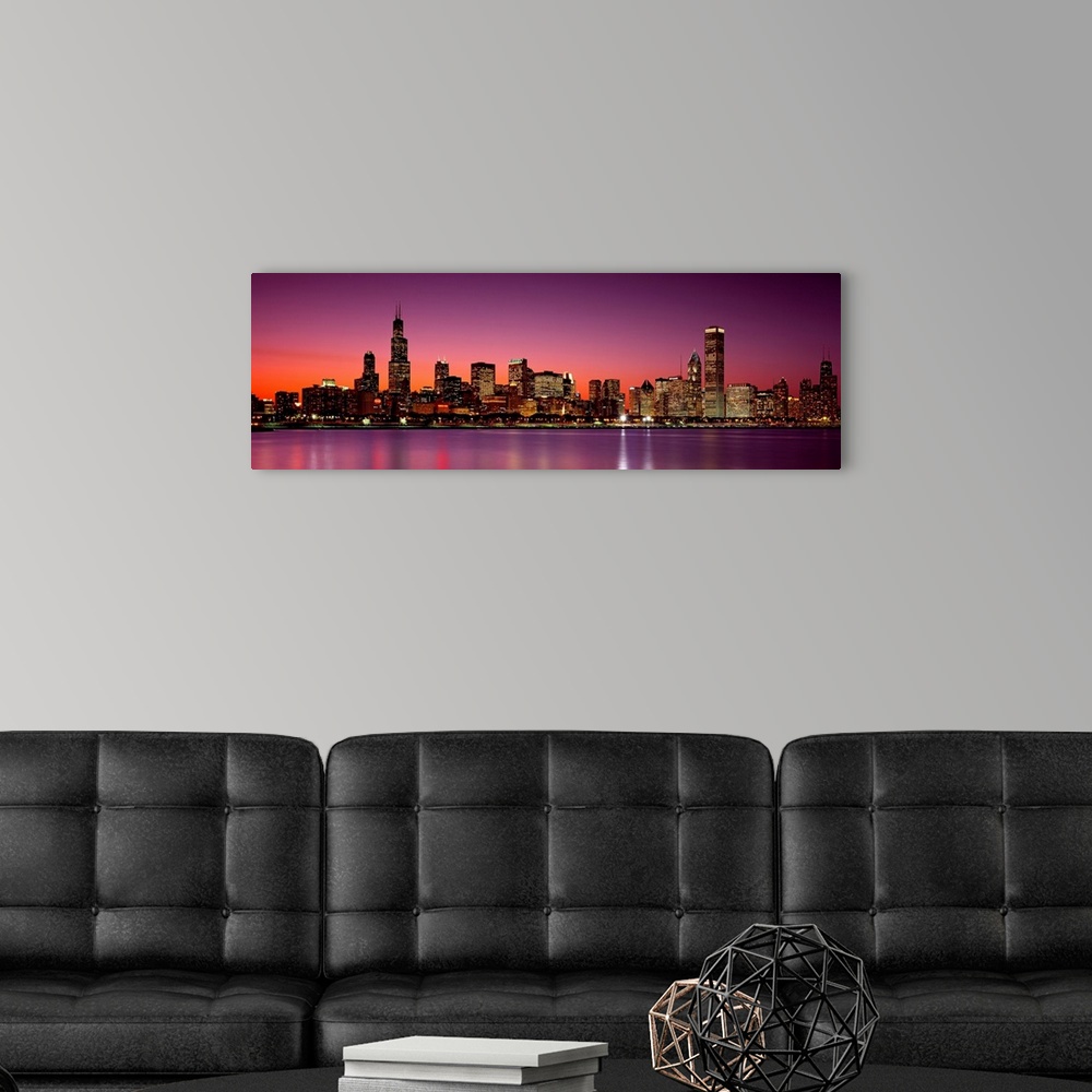 A modern room featuring Panoramic photograph of the busy skyline taken at dusk in Chicago, Illinois.  The bright lights c...