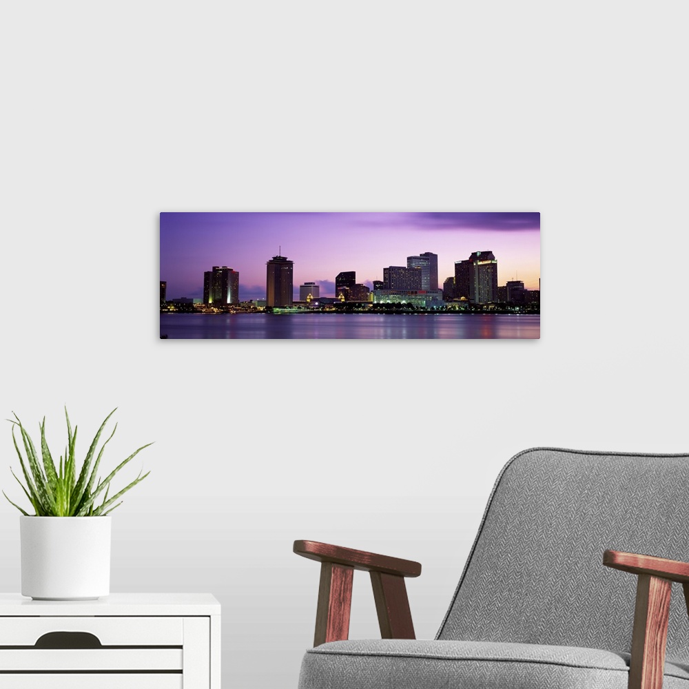 A modern room featuring Sunset panorama of the Downtown New Orleans skyline with the Mississippi River in the foreground.
