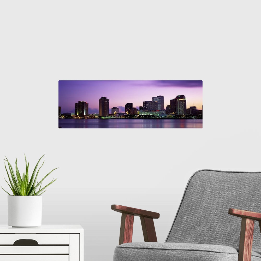 A modern room featuring Sunset panorama of the Downtown New Orleans skyline with the Mississippi River in the foreground.