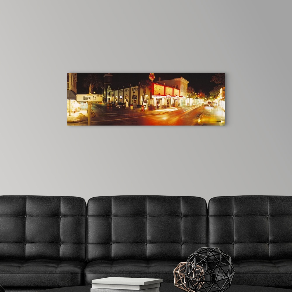 A modern room featuring Panoramic photograph taken of a street in Key West during the night with the shops lit up on the ...