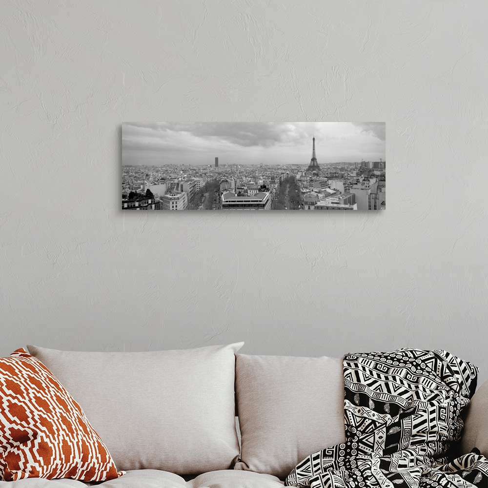 A bohemian room featuring An aerial, monochromatic photograph of the city skyline and two large tree lined avenues below in...