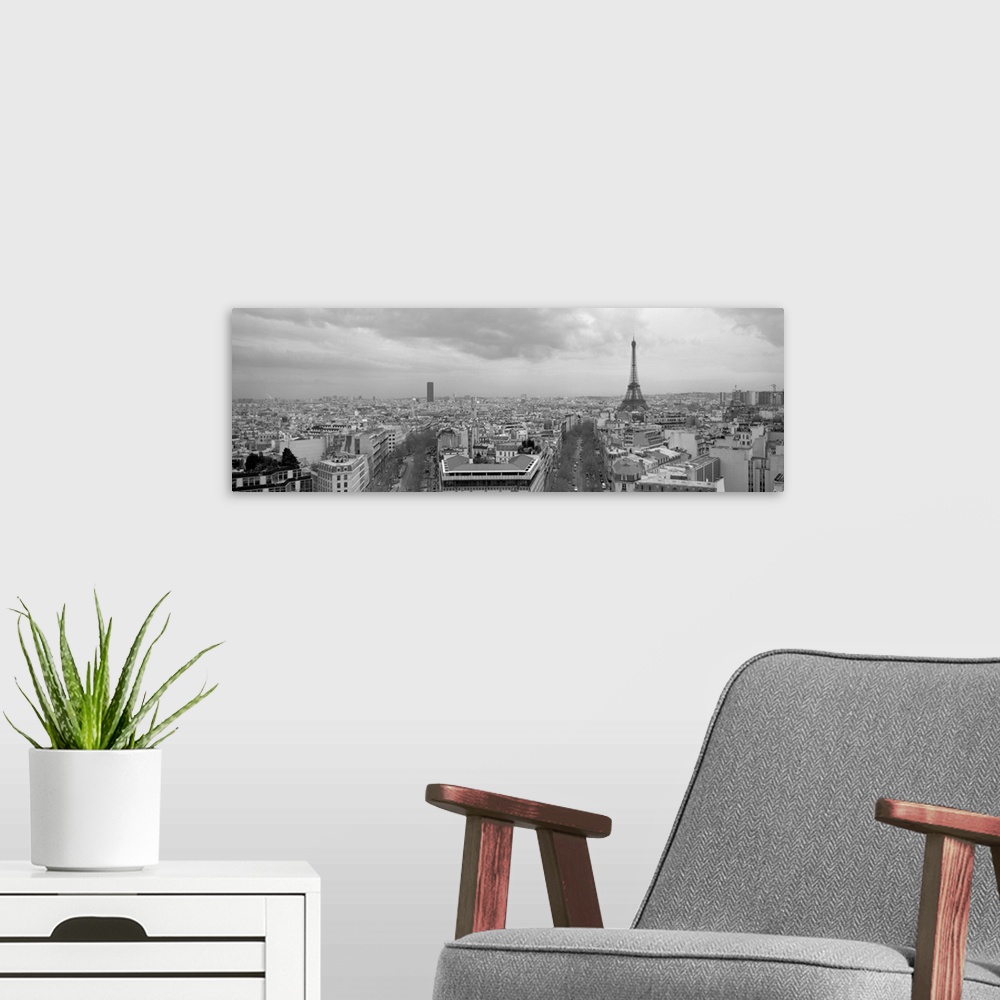 A modern room featuring An aerial, monochromatic photograph of the city skyline and two large tree lined avenues below in...