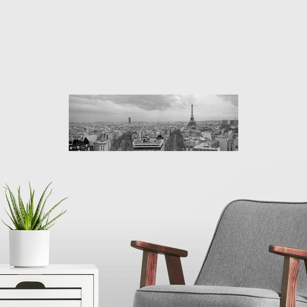 A modern room featuring An aerial, monochromatic photograph of the city skyline and two large tree lined avenues below in...
