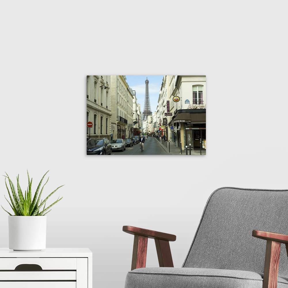 A modern room featuring Landscape photograph on an oversized canvas, looking down a street in Paris, full of cars and ped...