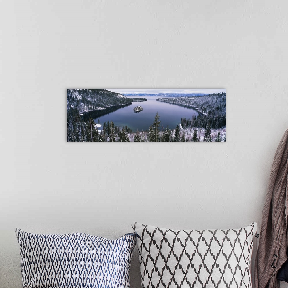 A bohemian room featuring Panoramic photograph of inlet surrounded by snow covered forest under a cloudy sky.
