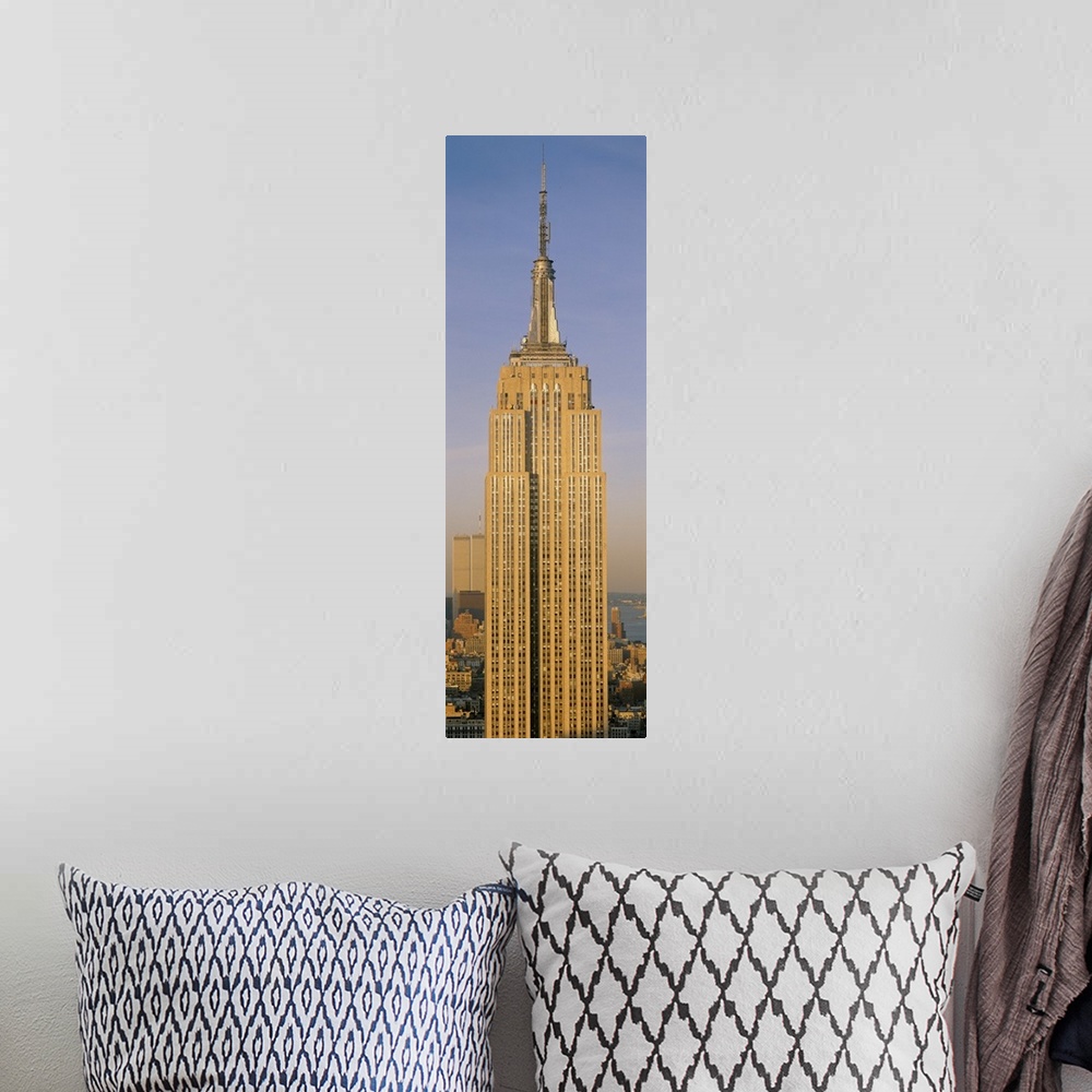 A bohemian room featuring A tall panoramic piece of just the Empire State Building with the sun hitting the side that was p...
