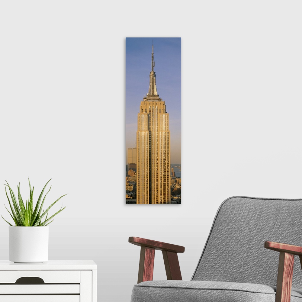 A modern room featuring A tall panoramic piece of just the Empire State Building with the sun hitting the side that was p...