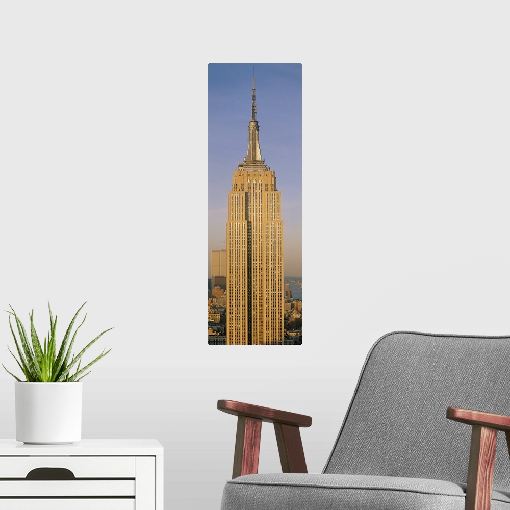 A modern room featuring A tall panoramic piece of just the Empire State Building with the sun hitting the side that was p...