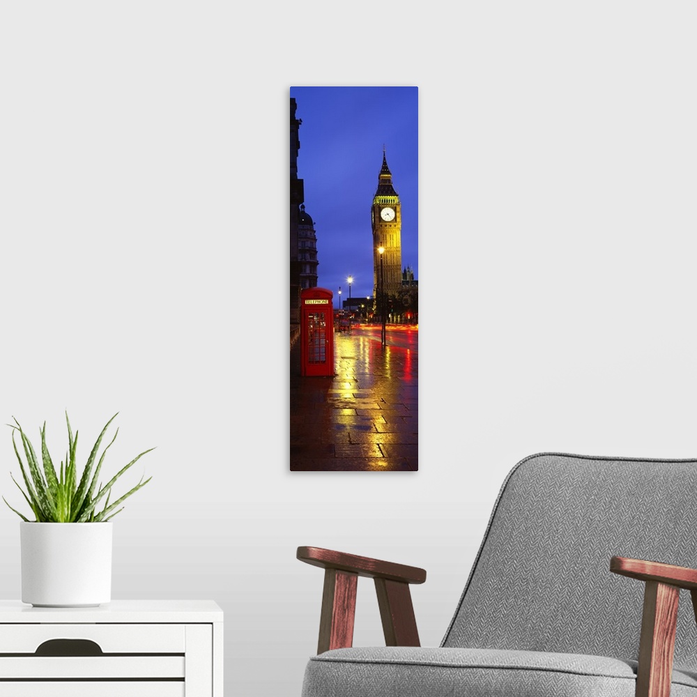 A modern room featuring A long vertical photograph of Big Ben at night with an old fashioned telephone booth to the left ...