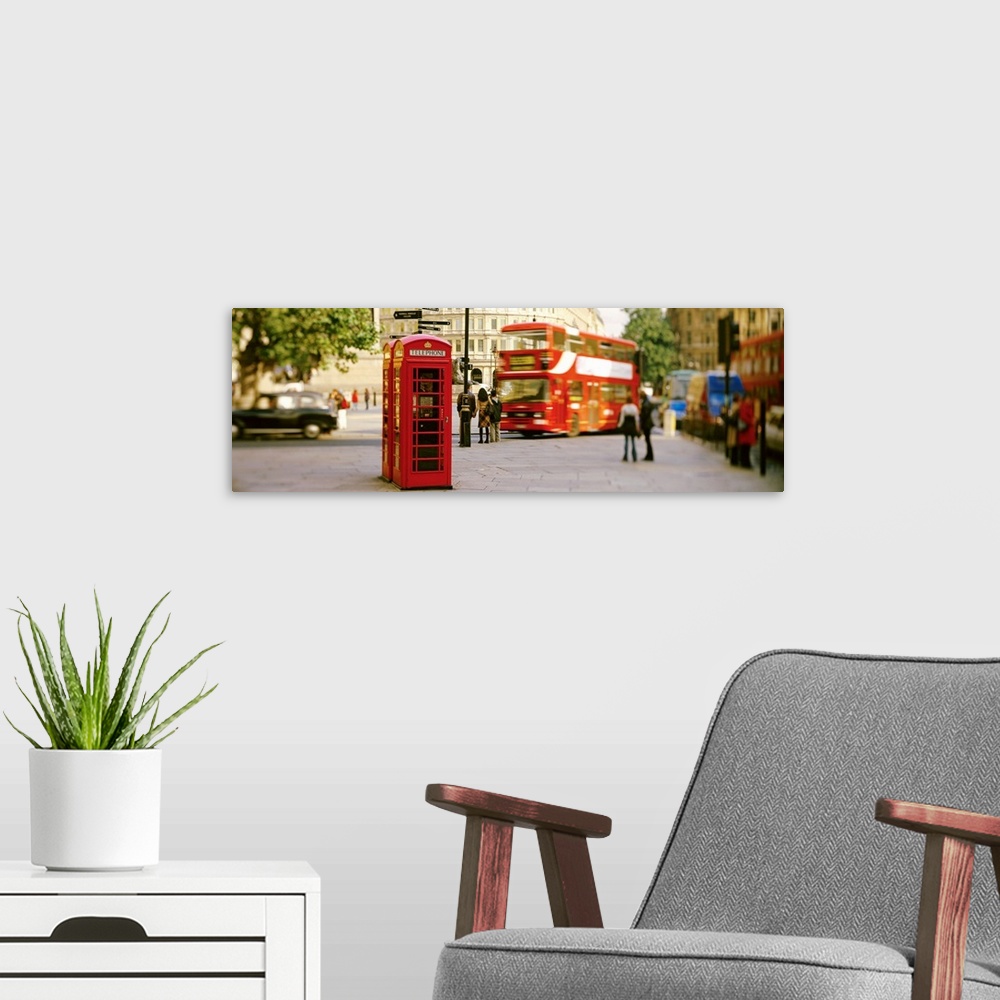 A modern room featuring Big horizontal photograph of a red telephone box in Trafalgar Square, London, surrounded by pedes...