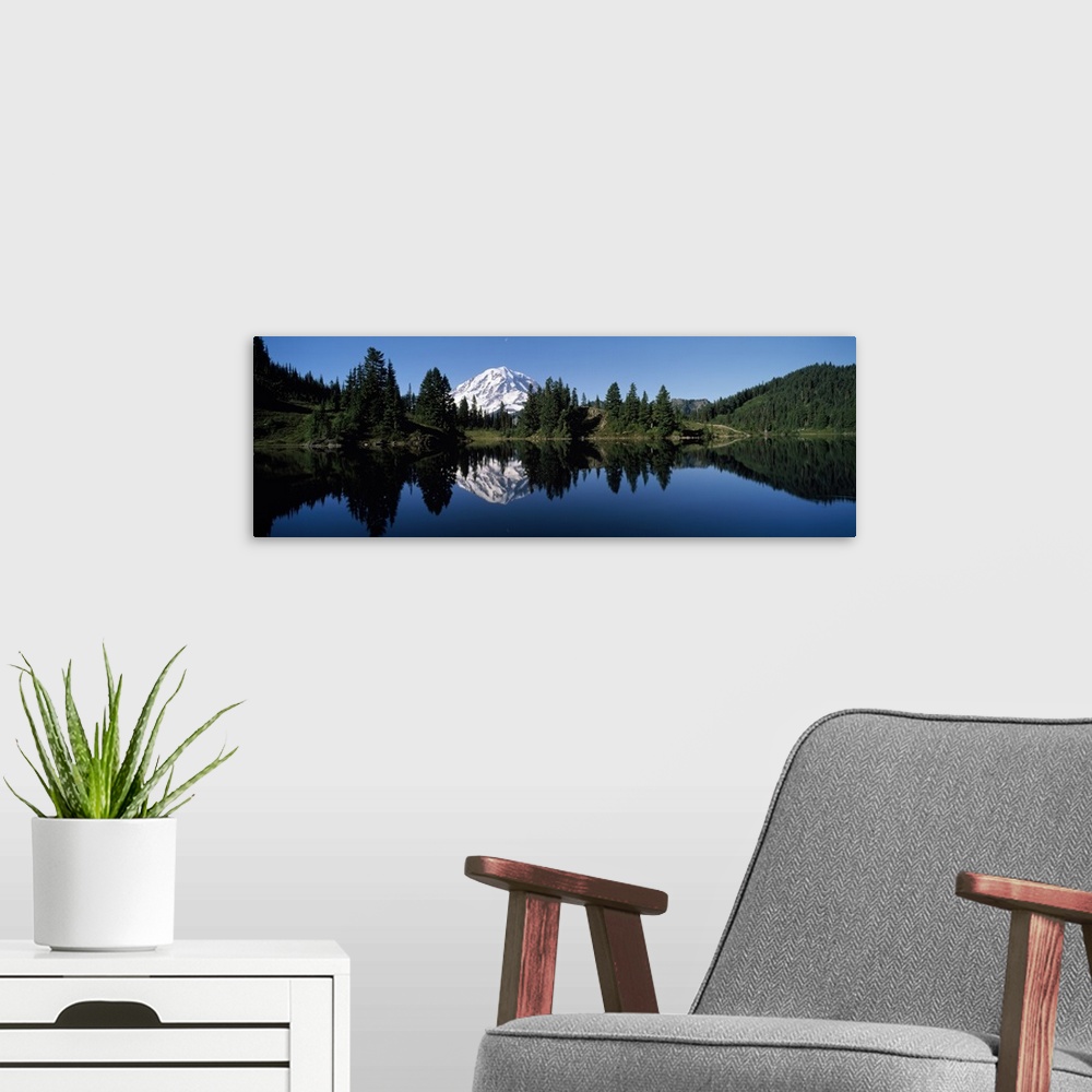 A modern room featuring Panoramic photograph of Mount Rainier and surrounding green forest, reflecting in the still water...