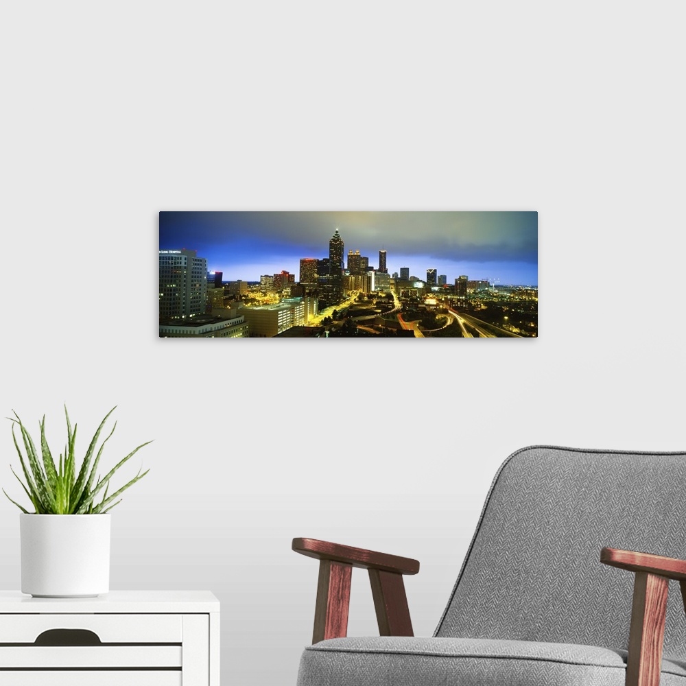 A modern room featuring Large horizontal photo on canvas of downtown Atlanta at night lit up.
