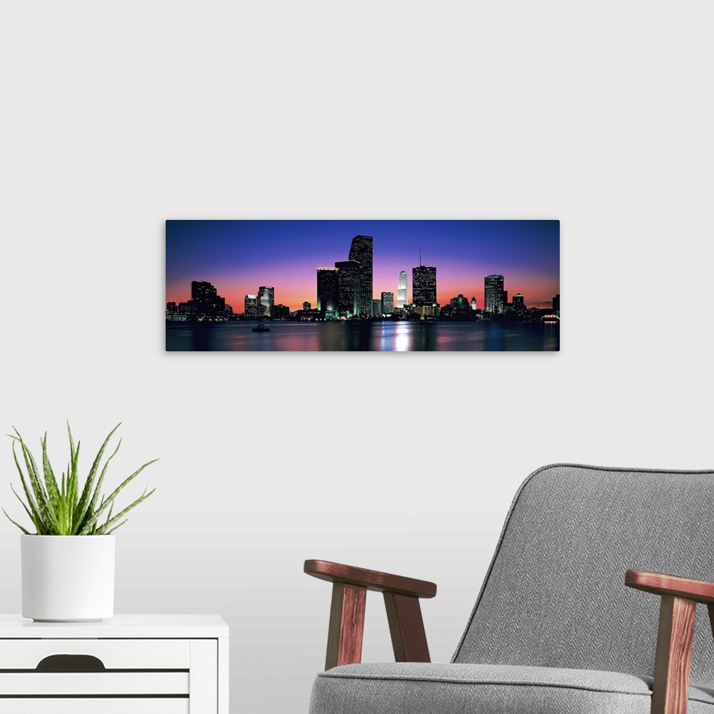 A modern room featuring Giant, panoramic photograph of the Miami skyline at night, reflecting over the waters of Biscayne...