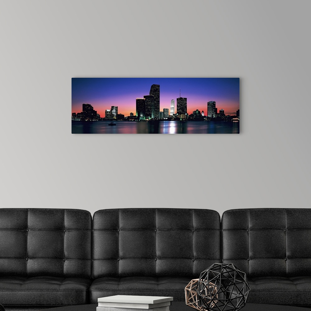 A modern room featuring Giant, panoramic photograph of the Miami skyline at night, reflecting over the waters of Biscayne...