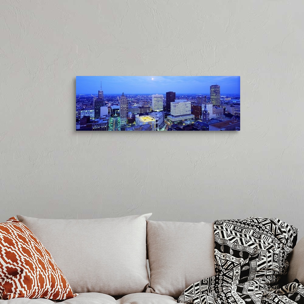 A bohemian room featuring This panoramic wall art is an aerial photograph of the city skyline at dusk with moon shining dow...