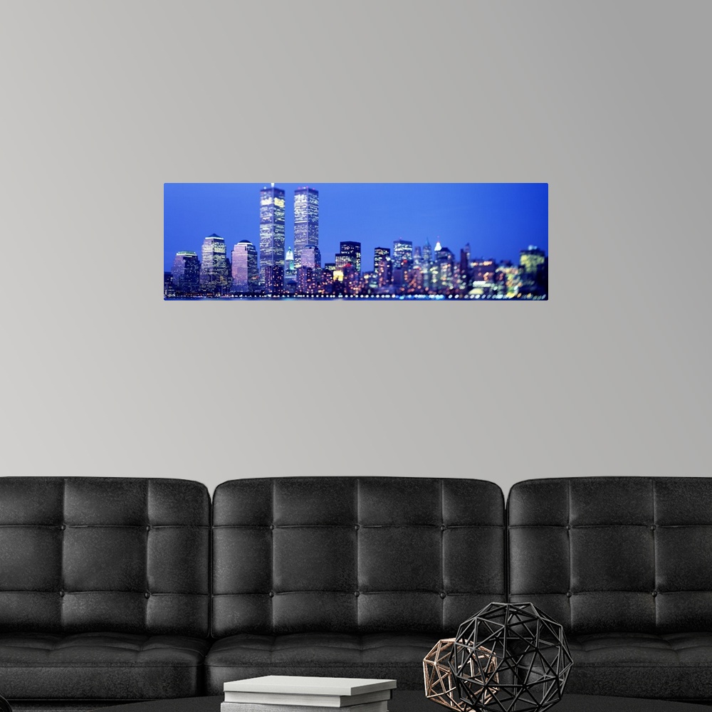 A modern room featuring Oversized landscape photograph of the brightly lit skyscrapers of the Manhattan skyline, includin...