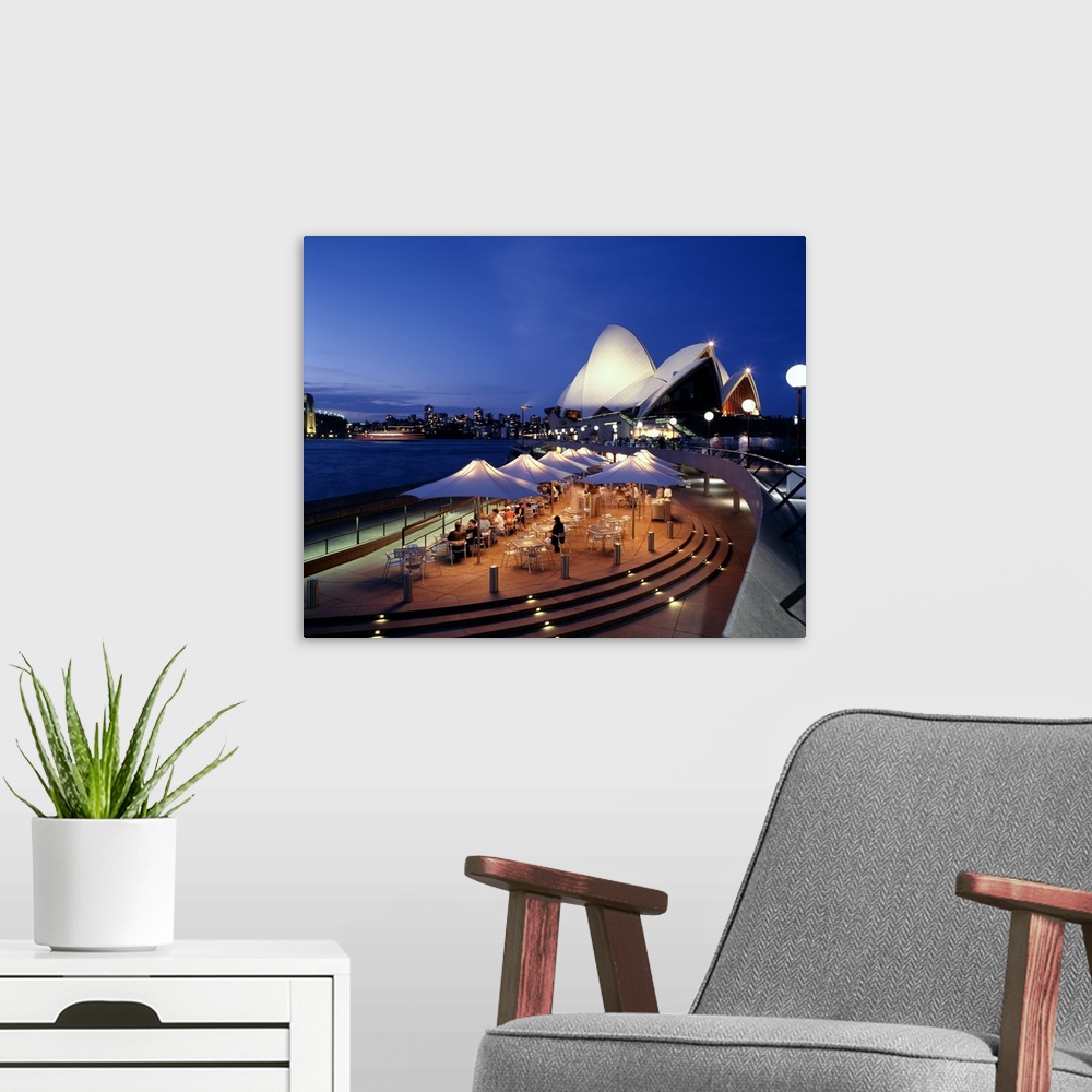 A modern room featuring A panorama of Sydney, Autralia's waterfront, featuring the Sydney Opera House and cafe.