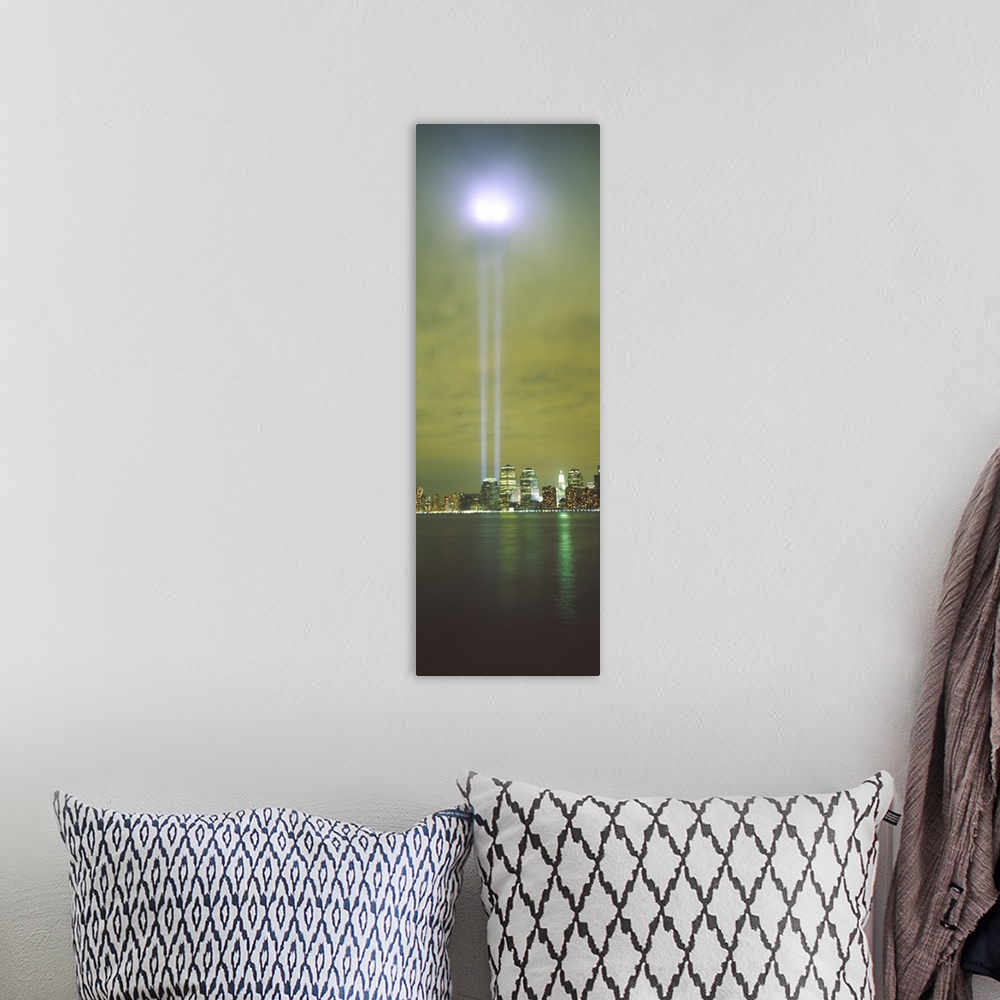 A bohemian room featuring Vertical panoramic piece of a photograph of the lights shining up from where the twin towers stood.