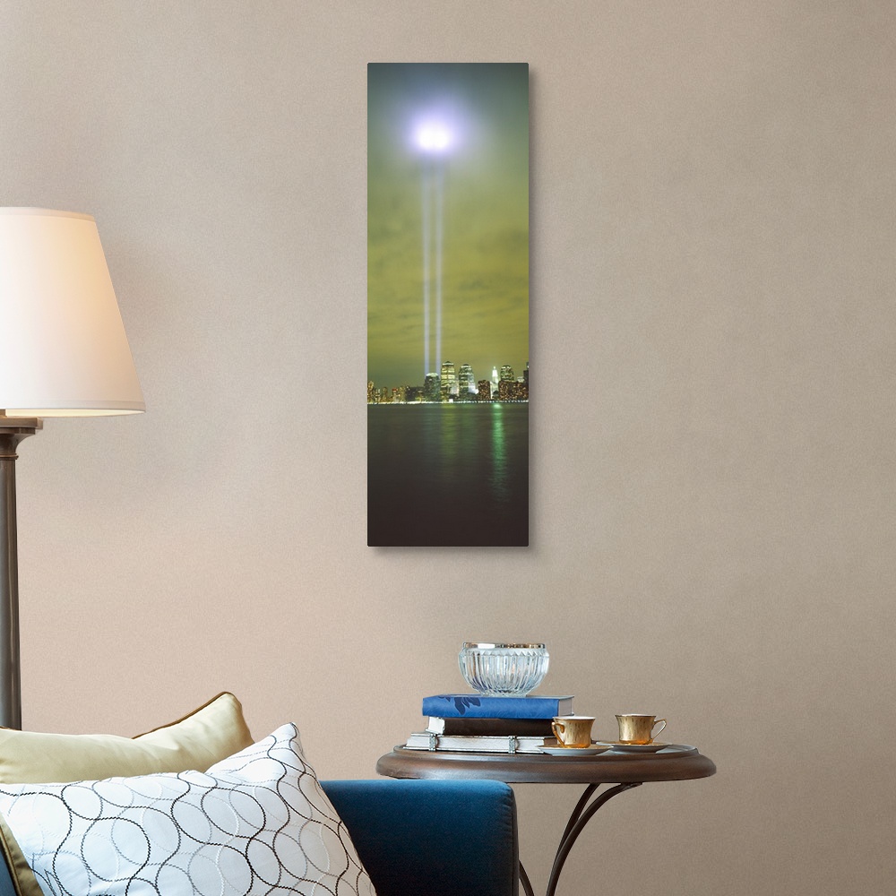 A traditional room featuring Vertical panoramic piece of a photograph of the lights shining up from where the twin towers stood.