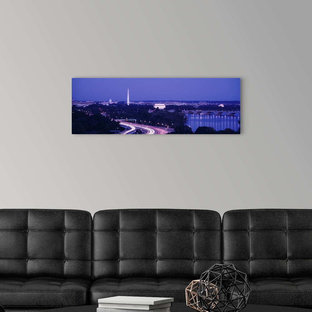A modern room featuring Wide angle view of the nations capital during dusk with the monuments lit up and the highway illu...