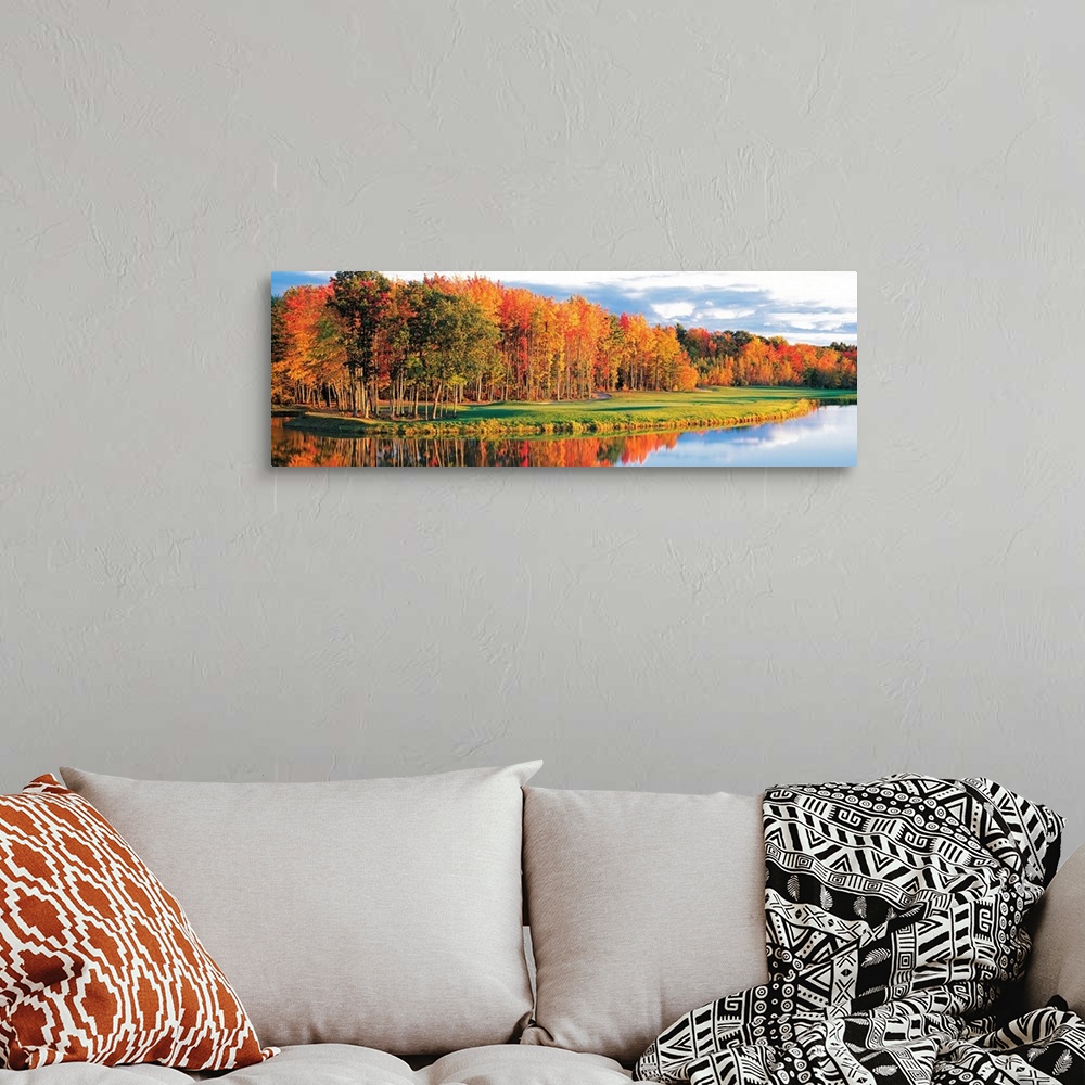 A bohemian room featuring Wide angle photograph of a bright autumn tree line along the waters edge, on a golf course in New...