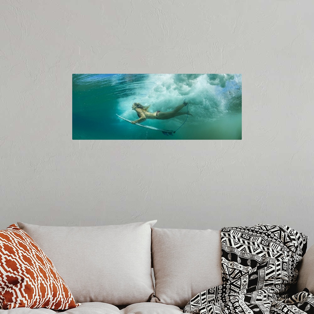 A bohemian room featuring Female surfer pushes under a wave while surfing, Clansthal, South Africa.