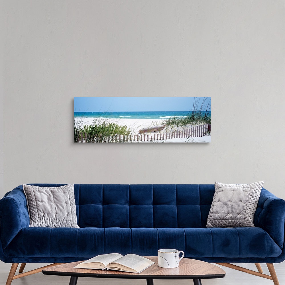 A modern room featuring Panoramic landscape photograph of a fence buried in the dunes on sandy beach on the Gulf Coast.