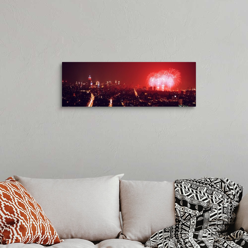 A bohemian room featuring This glowing panoramic wall art captures the burst of three rockets over the water as well as sev...