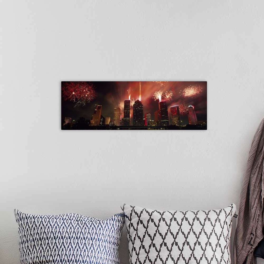 A bohemian room featuring Fireworks explode in the night sky behind the backdrop of the Houston downtown skyline.