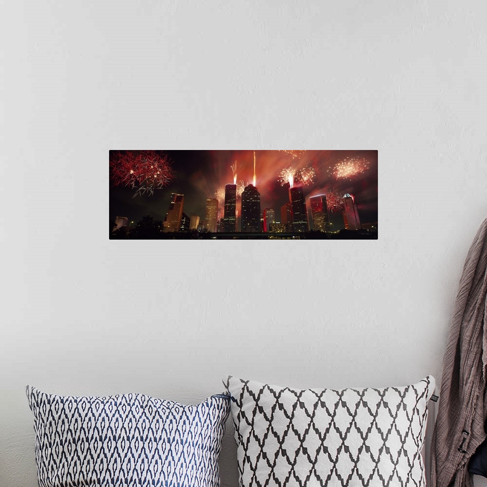 A bohemian room featuring Fireworks explode in the night sky behind the backdrop of the Houston downtown skyline.