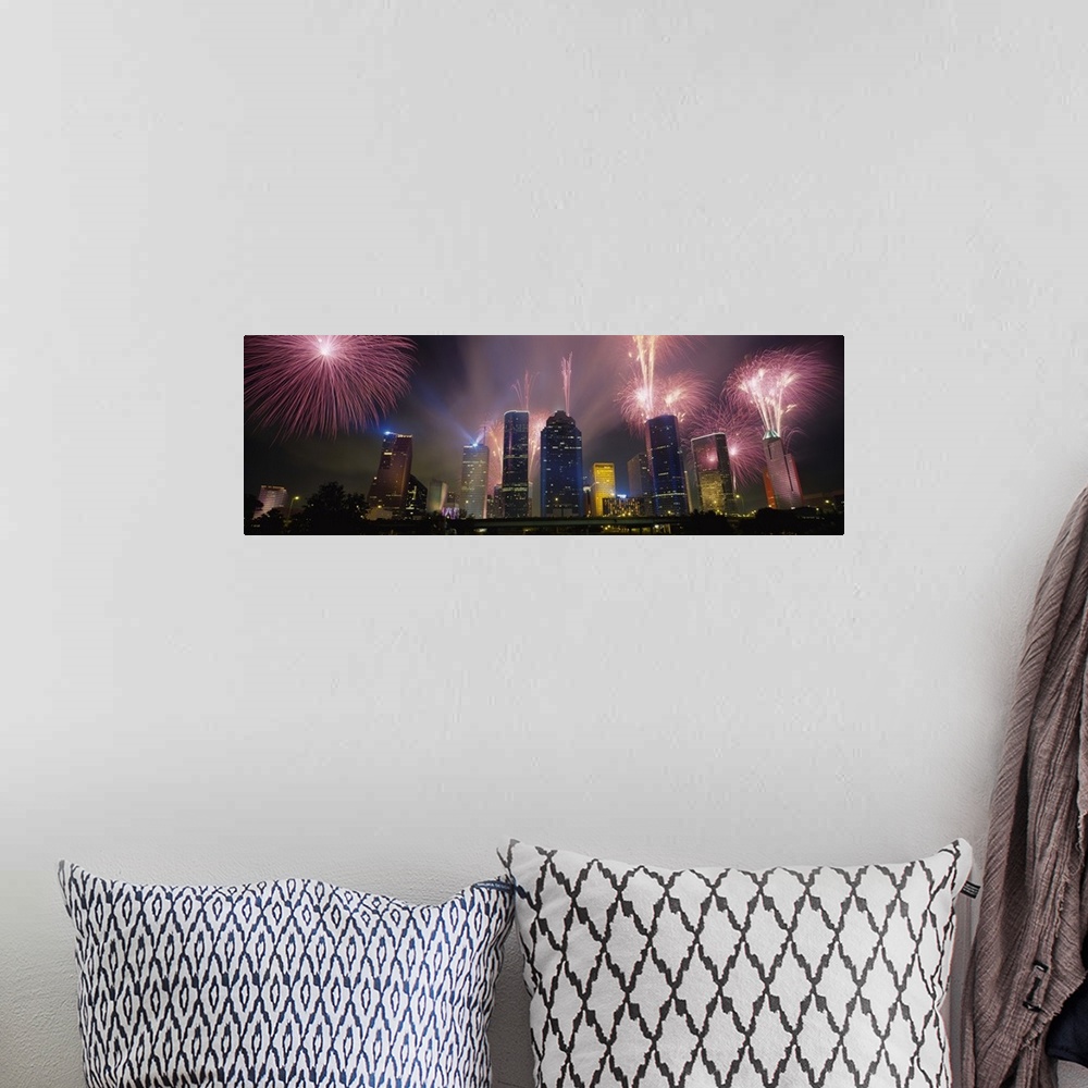 A bohemian room featuring Giant photograph at nighttime displays vibrant pyrotechnics bursting above a set of large skyscra...