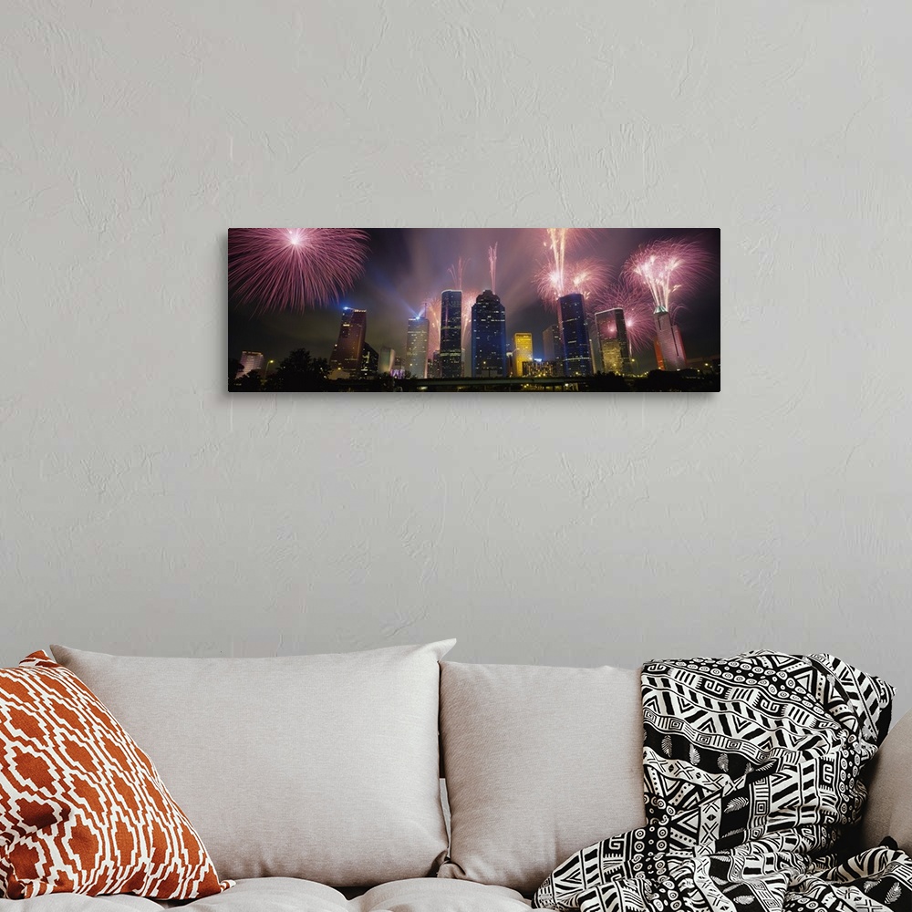 A bohemian room featuring Giant photograph at nighttime displays vibrant pyrotechnics bursting above a set of large skyscra...