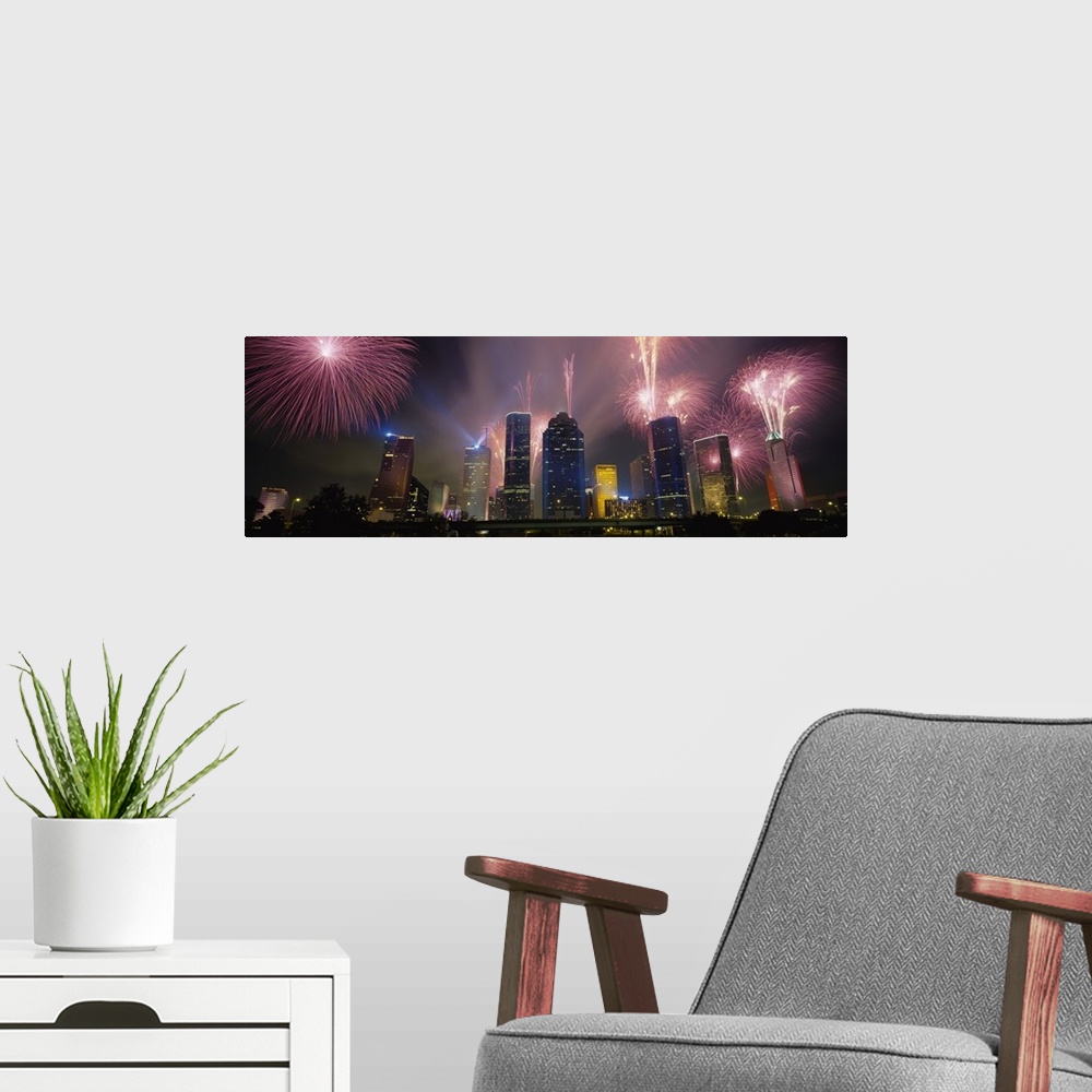 A modern room featuring Giant photograph at nighttime displays vibrant pyrotechnics bursting above a set of large skyscra...