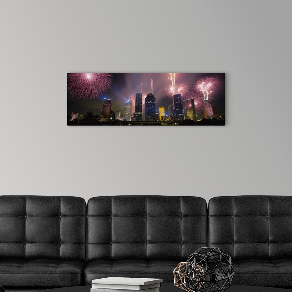 A modern room featuring Giant photograph at nighttime displays vibrant pyrotechnics bursting above a set of large skyscra...