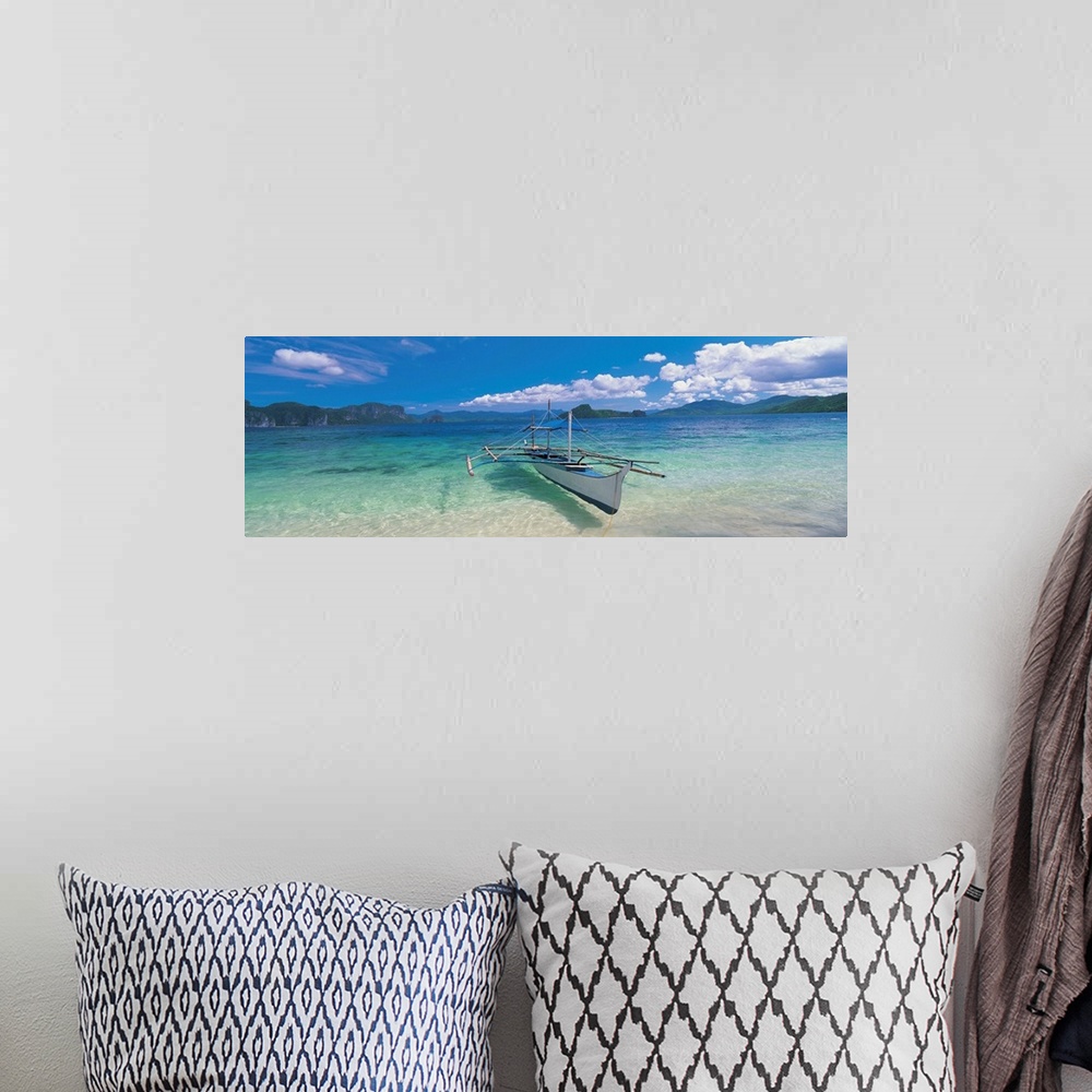 A bohemian room featuring Panoramic photograph of a canoe atop crystal clear waters with tree covered mountains and cliffs ...