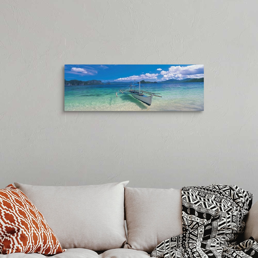 A bohemian room featuring Panoramic photograph of a canoe atop crystal clear waters with tree covered mountains and cliffs ...
