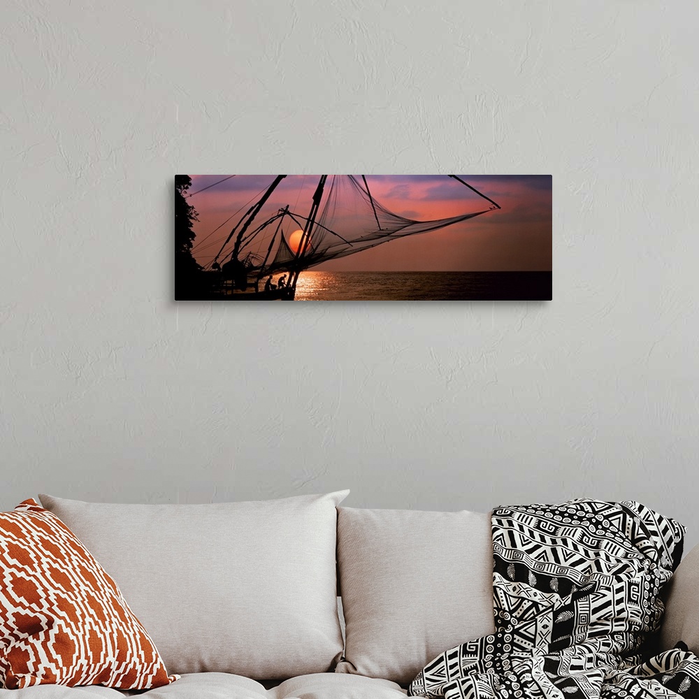 A bohemian room featuring Panoramic photo of fishing nets silhouetted against a big setting sun.
