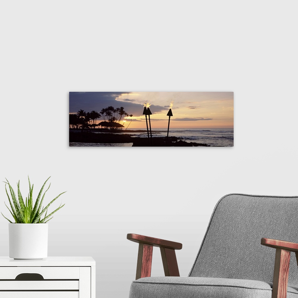 A modern room featuring Panoramic photograph of silhouetted palm trees and land reaching into dark waters beneath the set...