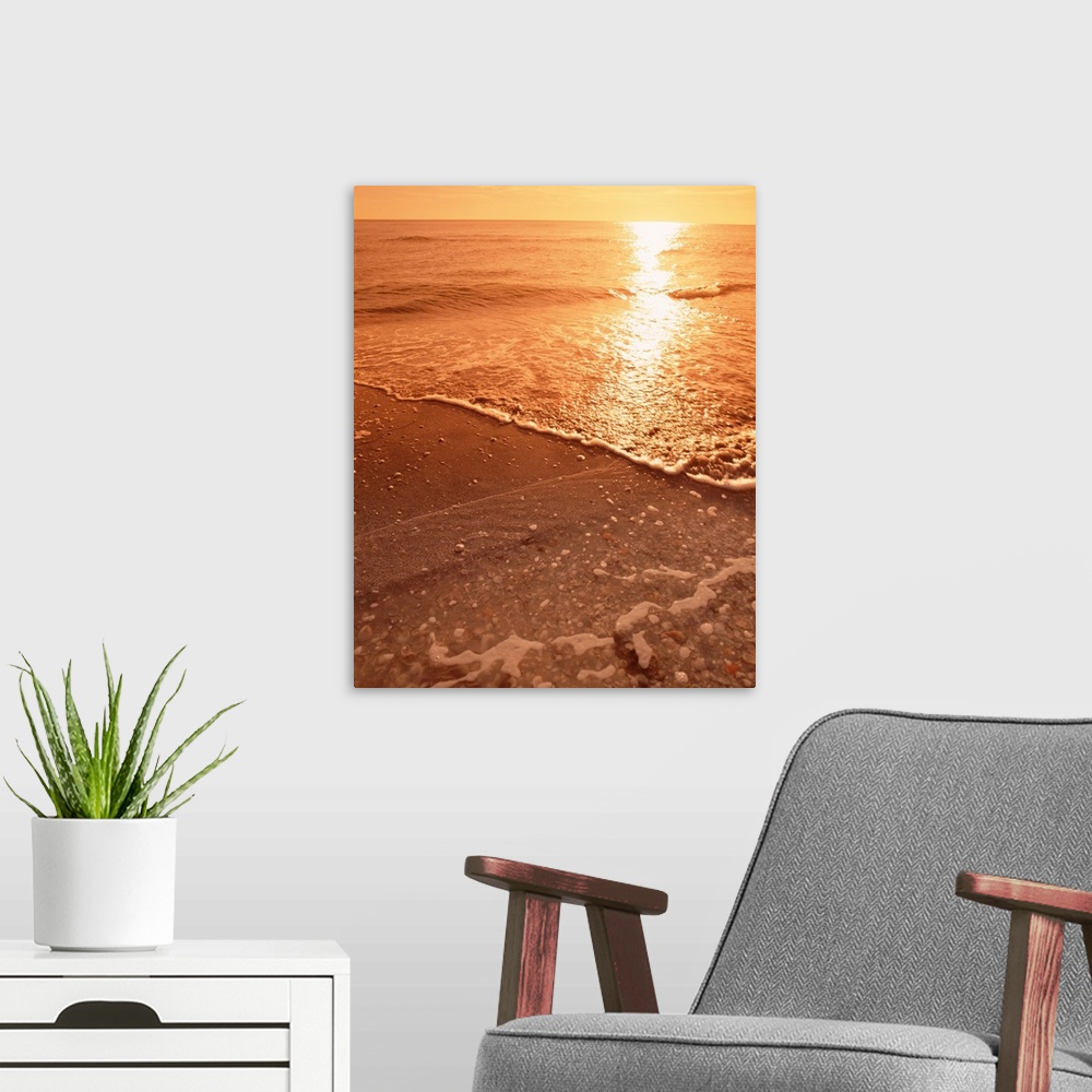 A modern room featuring Vertical photograph on a big canvas water rushing onto the shore of Sanibel Beach, Florida in the...