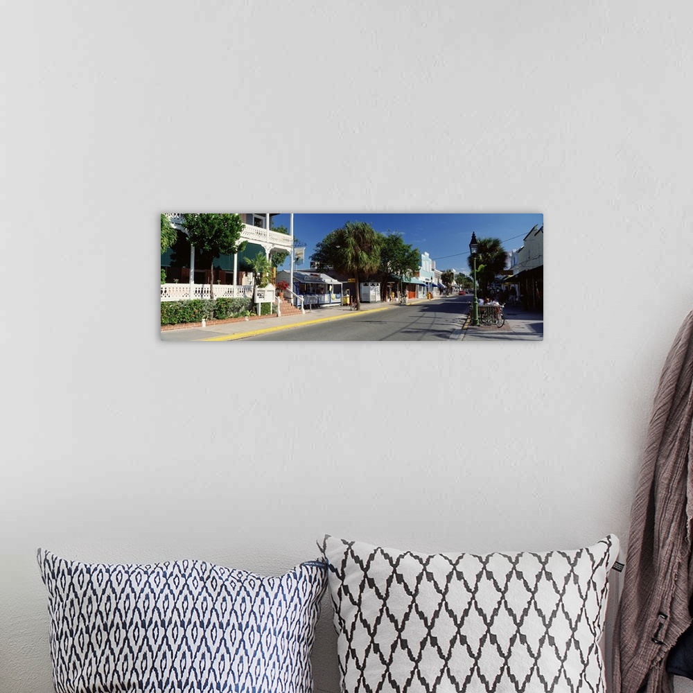 A bohemian room featuring Panoramic photograph of street lined with shops in southern beach town.