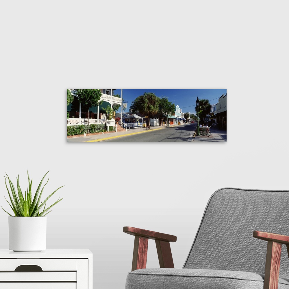 A modern room featuring Panoramic photograph of street lined with shops in southern beach town.