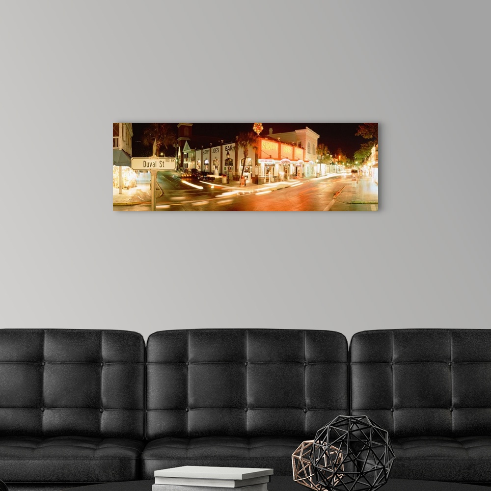 A modern room featuring Panoramic photograph of street level view of busy intersection.  The buildings are lit up and the...