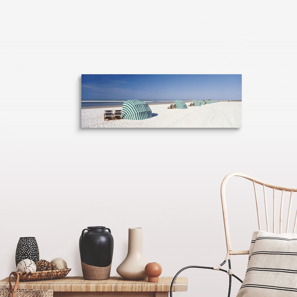 A farmhouse room featuring Panoramic photograph of shoreline wish beach chairs and umbrellas under a clear sky.