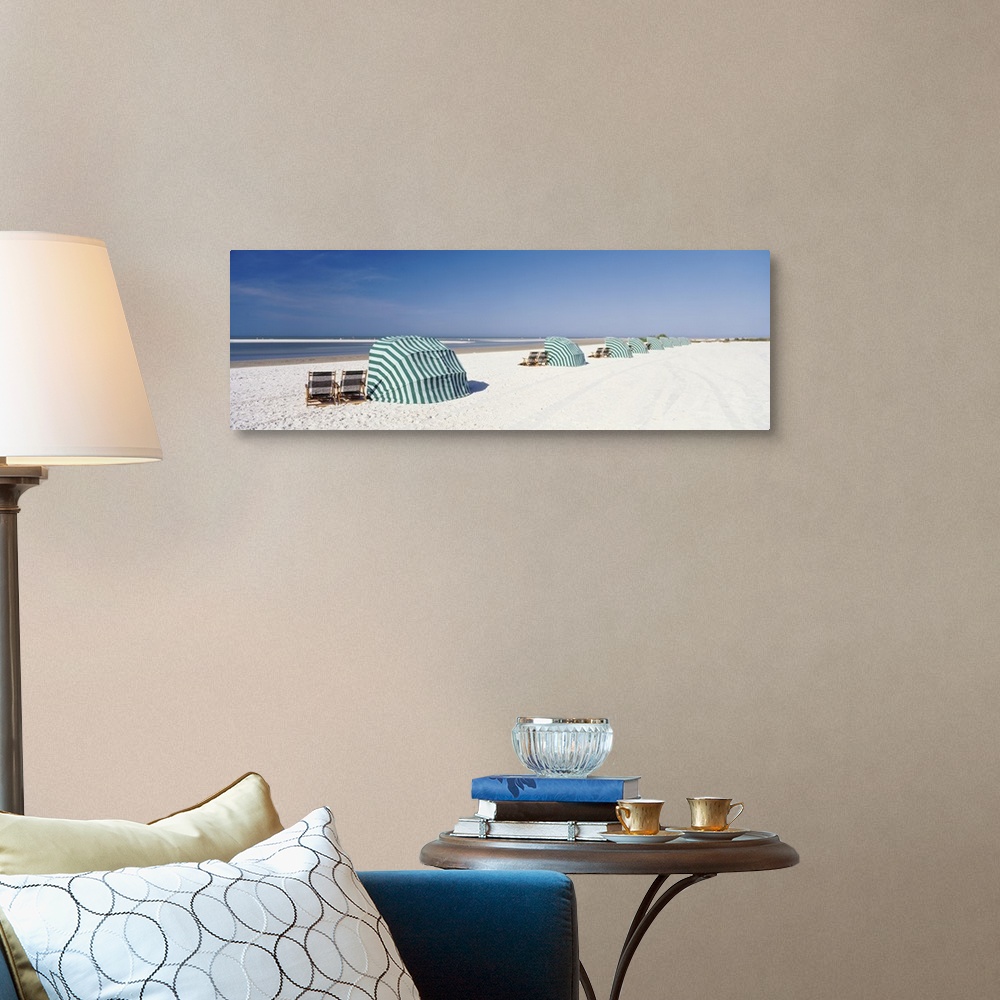 A traditional room featuring Panoramic photograph of shoreline wish beach chairs and umbrellas under a clear sky.