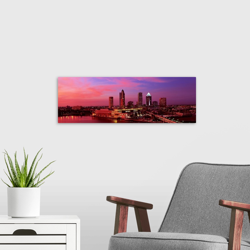 A modern room featuring This is a panoramic photograph of the city as the sunsets out of frame.