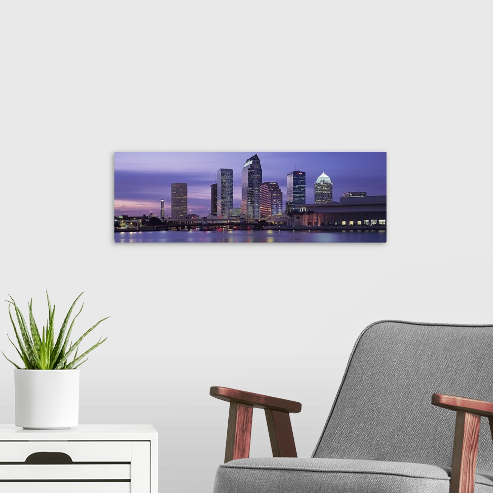 A modern room featuring Panoramic photograph taken at nighttime of a group of skyscrapers within a busy city in the South...