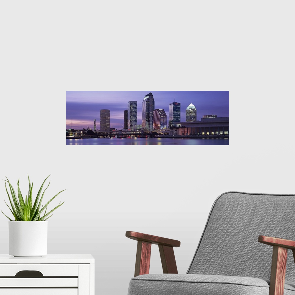 A modern room featuring Panoramic photograph taken at nighttime of a group of skyscrapers within a busy city in the South...