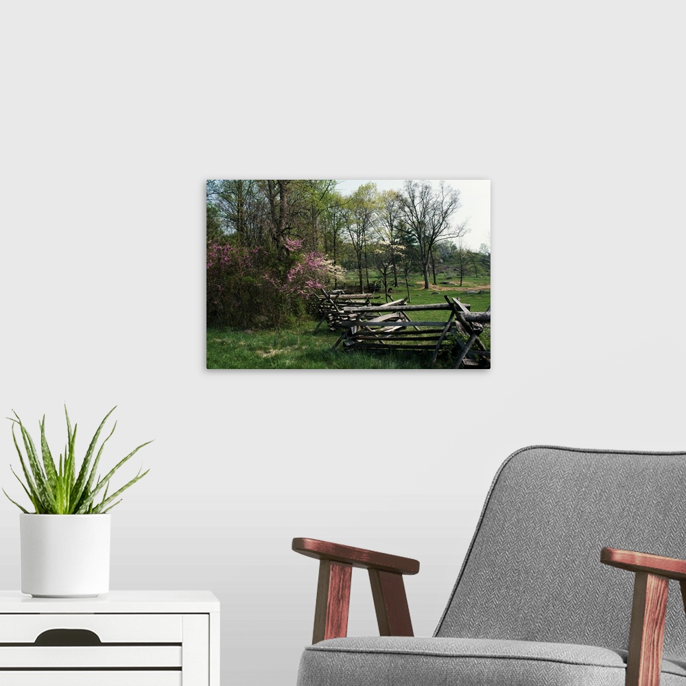 A modern room featuring This home docor accent is a landscape photograph of a primitive fence passing through a meadow su...