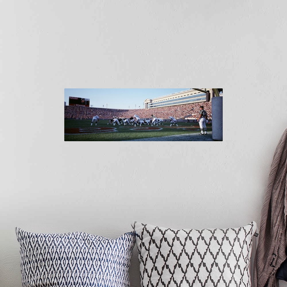 A bohemian room featuring Panoramic picture taken of the Chicago bears on the field at the scrimmage line with the stadium ...