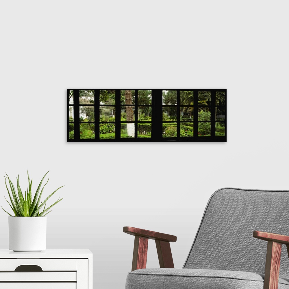 A modern room featuring Panoramic image looking out of a silhouetted window into a garden.
